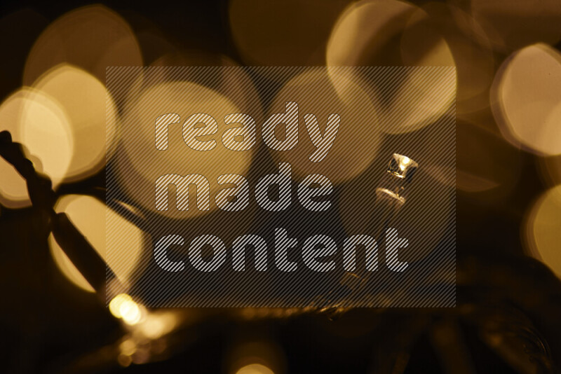 Light bulbs glowing against backdrop of golden bokeh