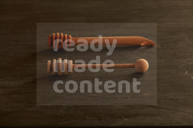 Wooden honey dipper on black slate background