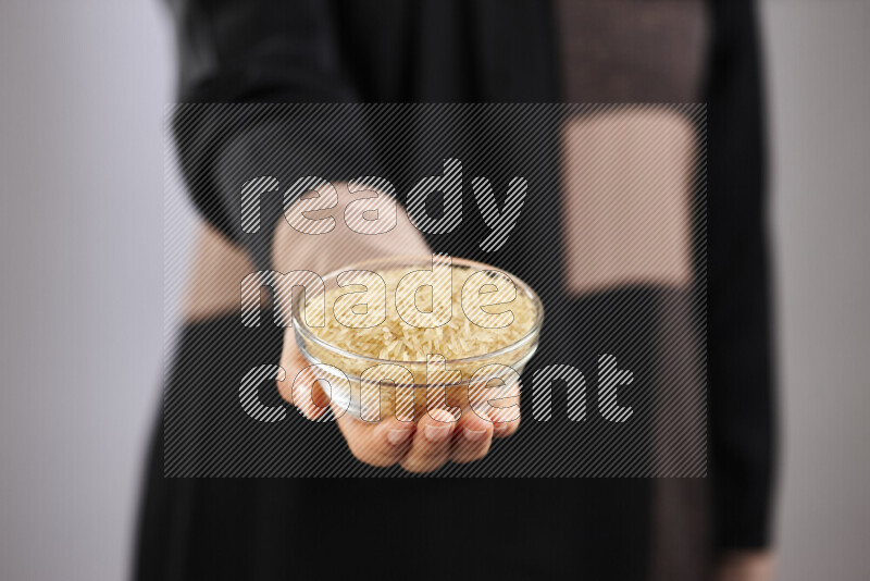 Woman in abaya holding different kinds of legumes in different positions