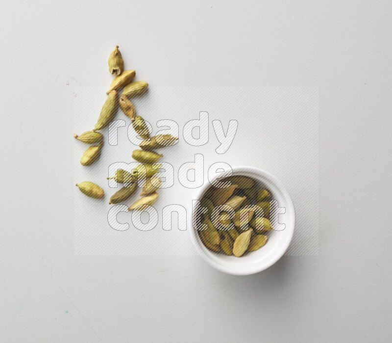 Top-view shot of Cardamon in a container on white background