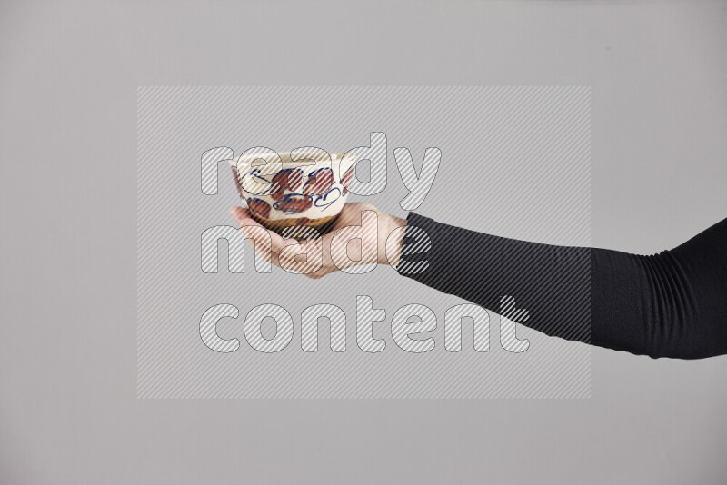 A woman in black abaya holding different pottery essentials in different positions