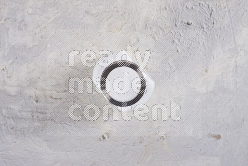 A glass jar full of fine table salt on white background