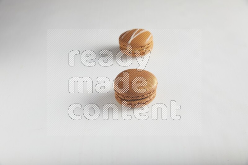 45º Shot of of two assorted Brown Irish Cream, and Brown Coffee macarons  on white background