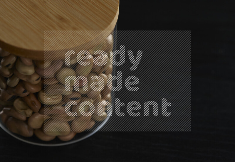 فول تدميس في وعاء زجاجي على خلفية سوداء