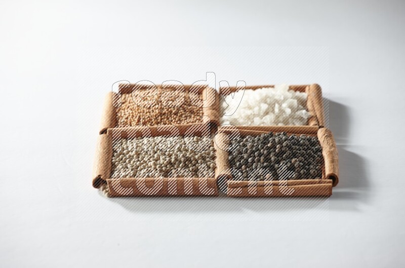 4 squares of cinnamon sticks full of mustard, salt, white pepper and black pepper on white flooring