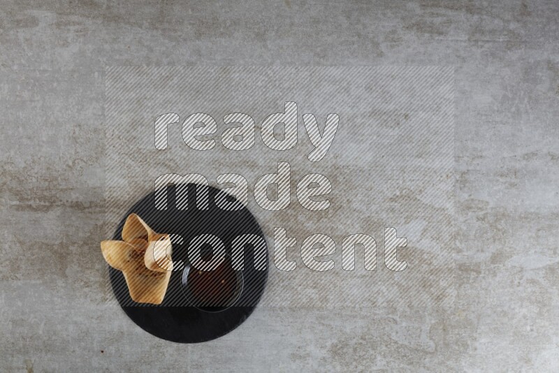 wonton cups with soy sauce ramkin on circle slate on grey textured counter top