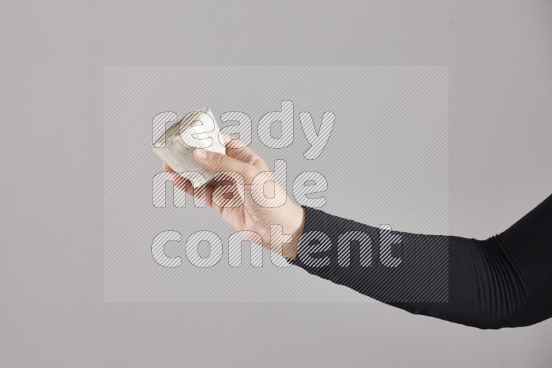 A woman in black abaya holding different pottery essentials in different positions