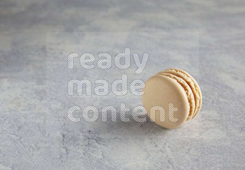 45º Shot of white marbleCaramel fleur de sel macaron on white  marble background