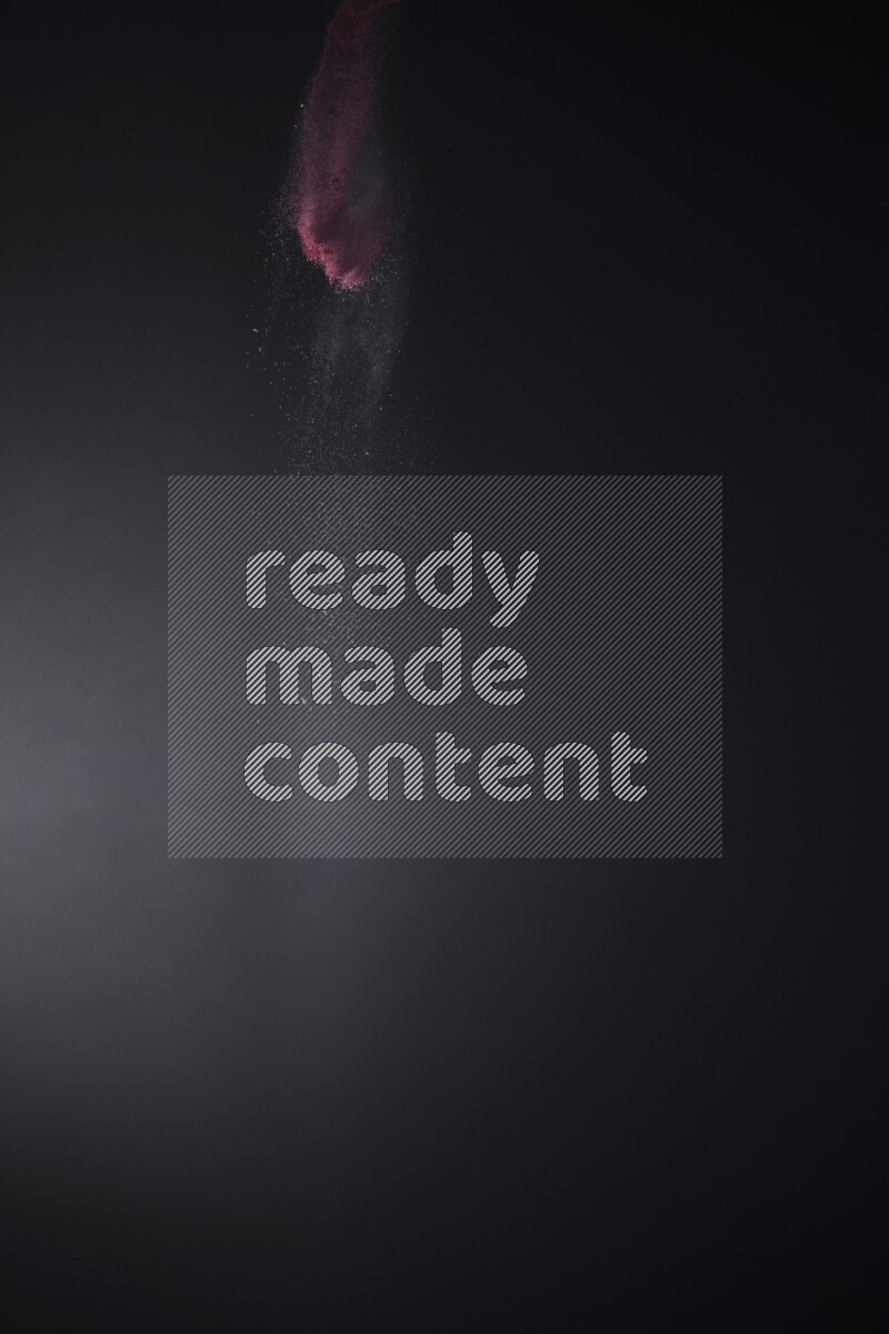 A side view of red powder explosion on black background