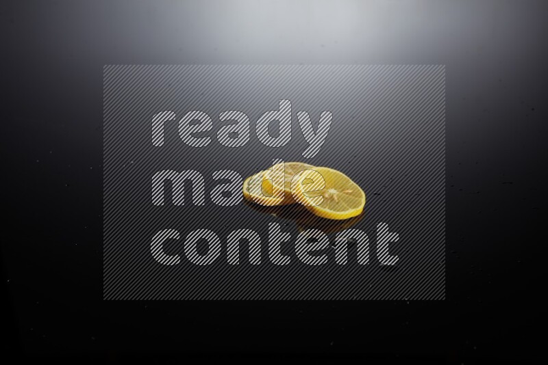 Lemon slices with water drops, and droplets on black background