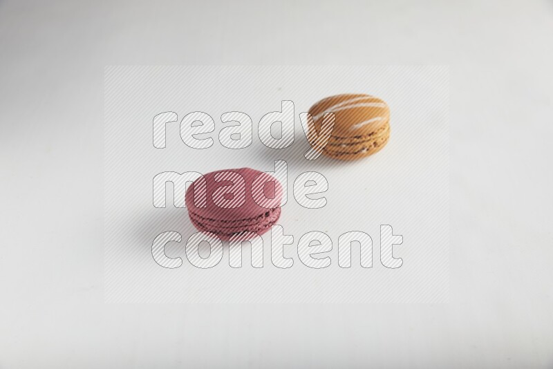 45º Shot of of two assorted Brown Irish Cream, and Red Cherry macarons on white background