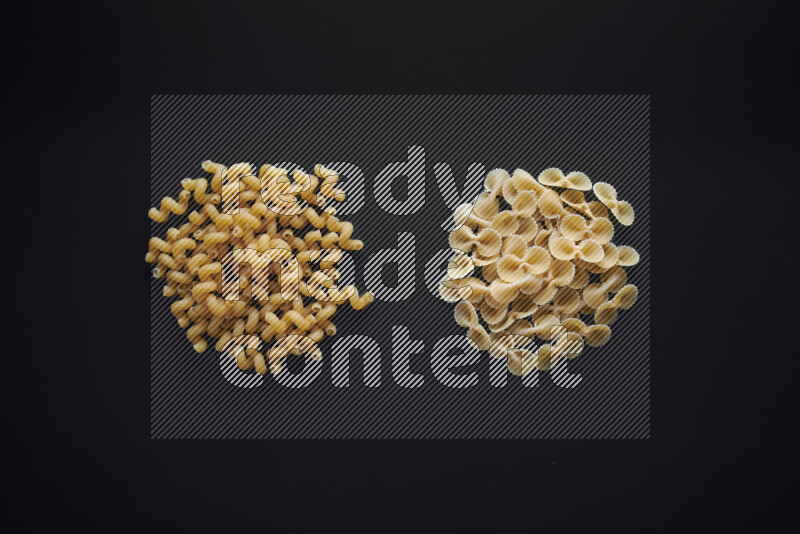 Different pasta types in bunches on black background