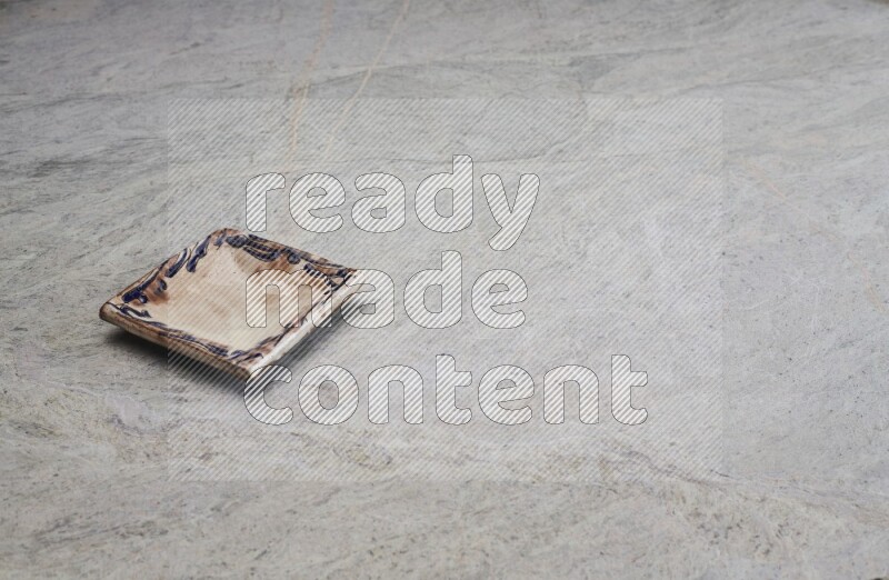 A decorative pottery plate on grey marble background