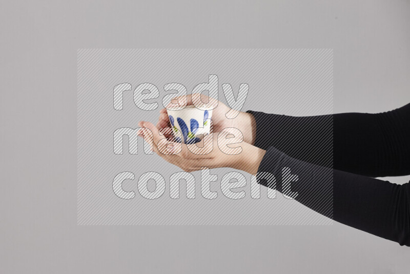 A woman in black abaya holding different pottery essentials in different positions