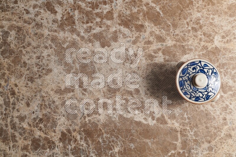 A multicolored pottery pot on beige marble background
