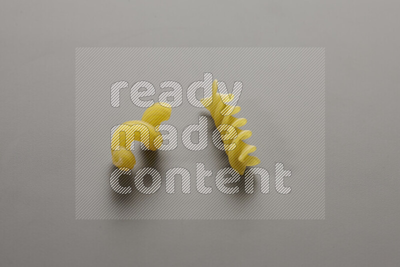 Twist pasta with other types of pasta on grey background