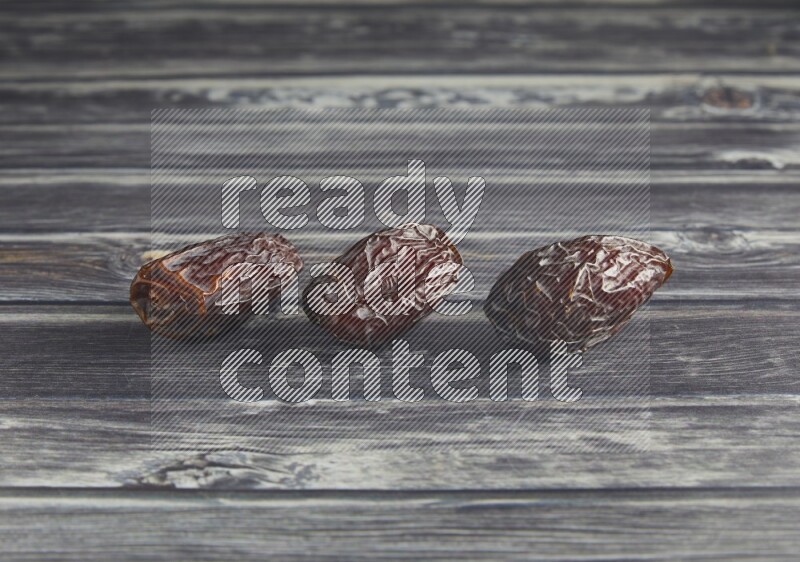 three madjoul date on a wooden grey background
