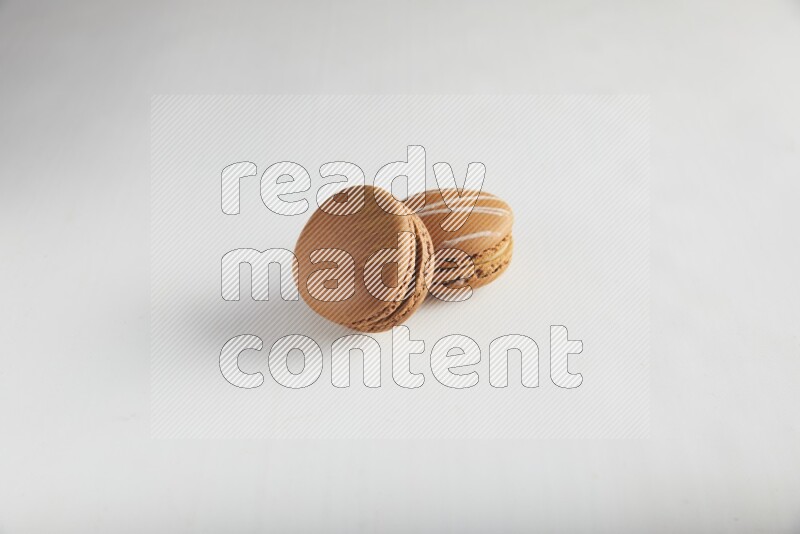 45º Shot of of two assorted Brown Irish Cream, and Brown Coffee macarons  on white background
