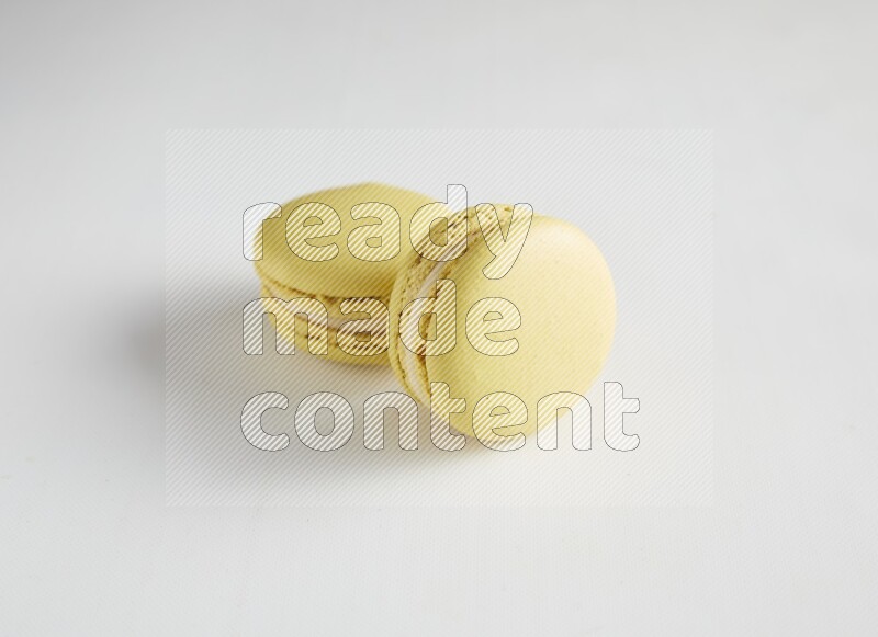 45º Shot of two Yellow Lime macarons on white background