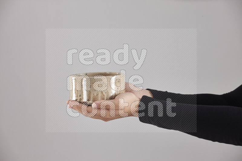 A woman in black abaya holding different pottery essentials in different positions