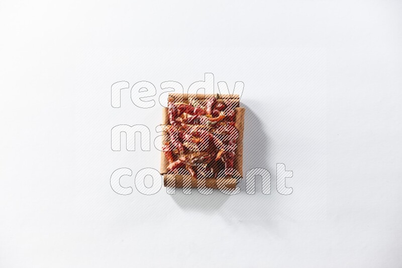 A single square of cinnamon sticks full of chilis on white flooring
