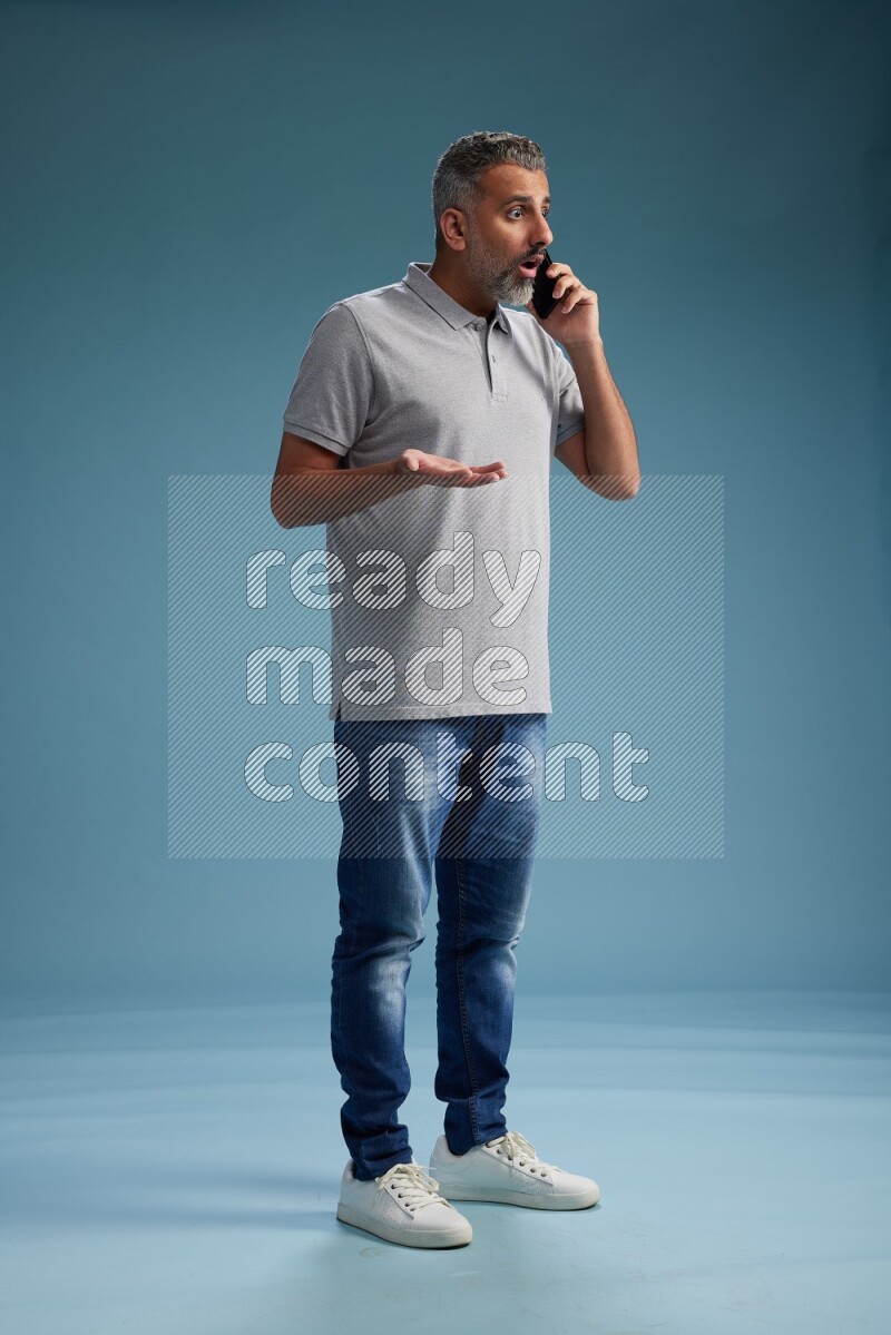 Man Standing talking on phone on blue background