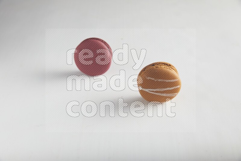 45º Shot of of two assorted Brown Irish Cream, and Red Cherry macarons on white background