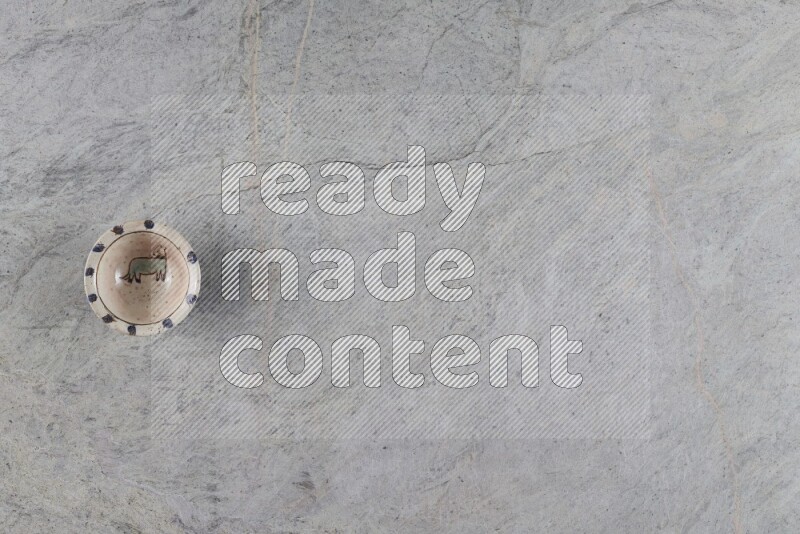 A decorative pottery plate on grey marble background