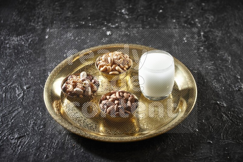 Nuts in metal bowls with sobya on a tray in dark setup