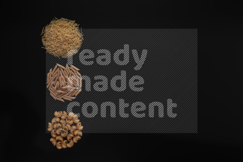 Different pasta types in 3 bunches on black background