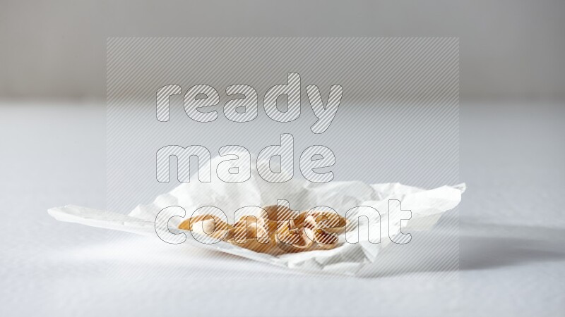 Pistachio peels on a crumpled piece of paper on a white background in different angles