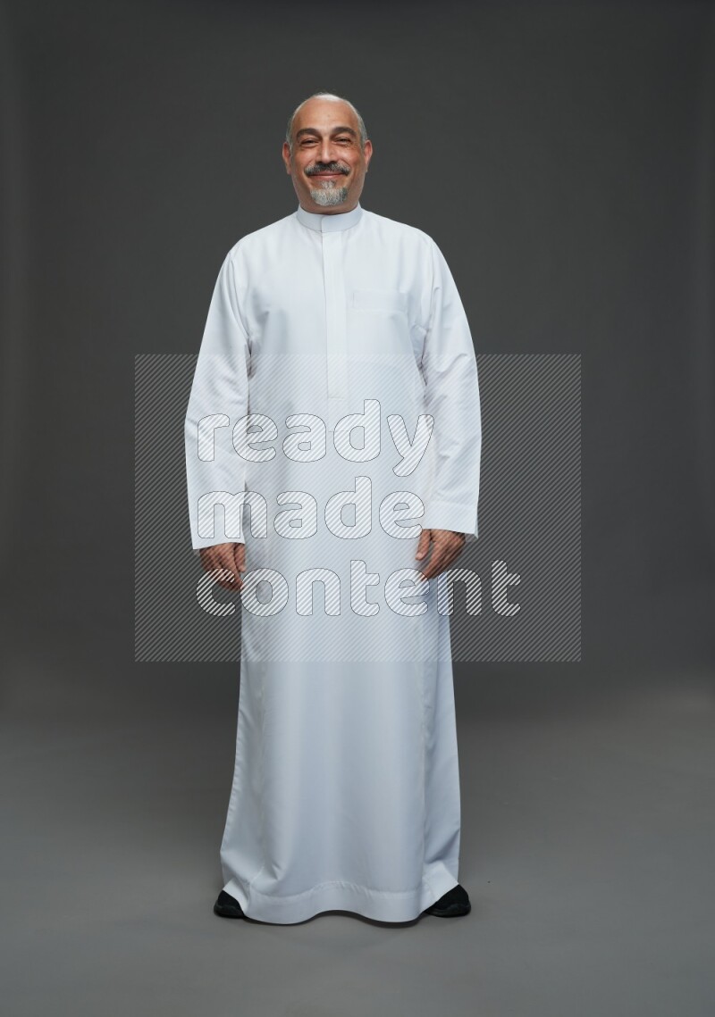 Saudi man without shomag Standing Interacting with the camera on gray background