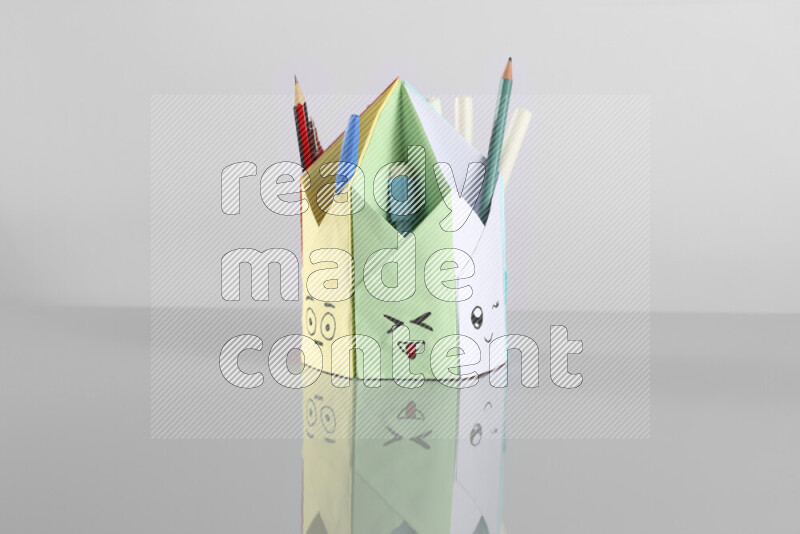 Origami pen holder on grey background