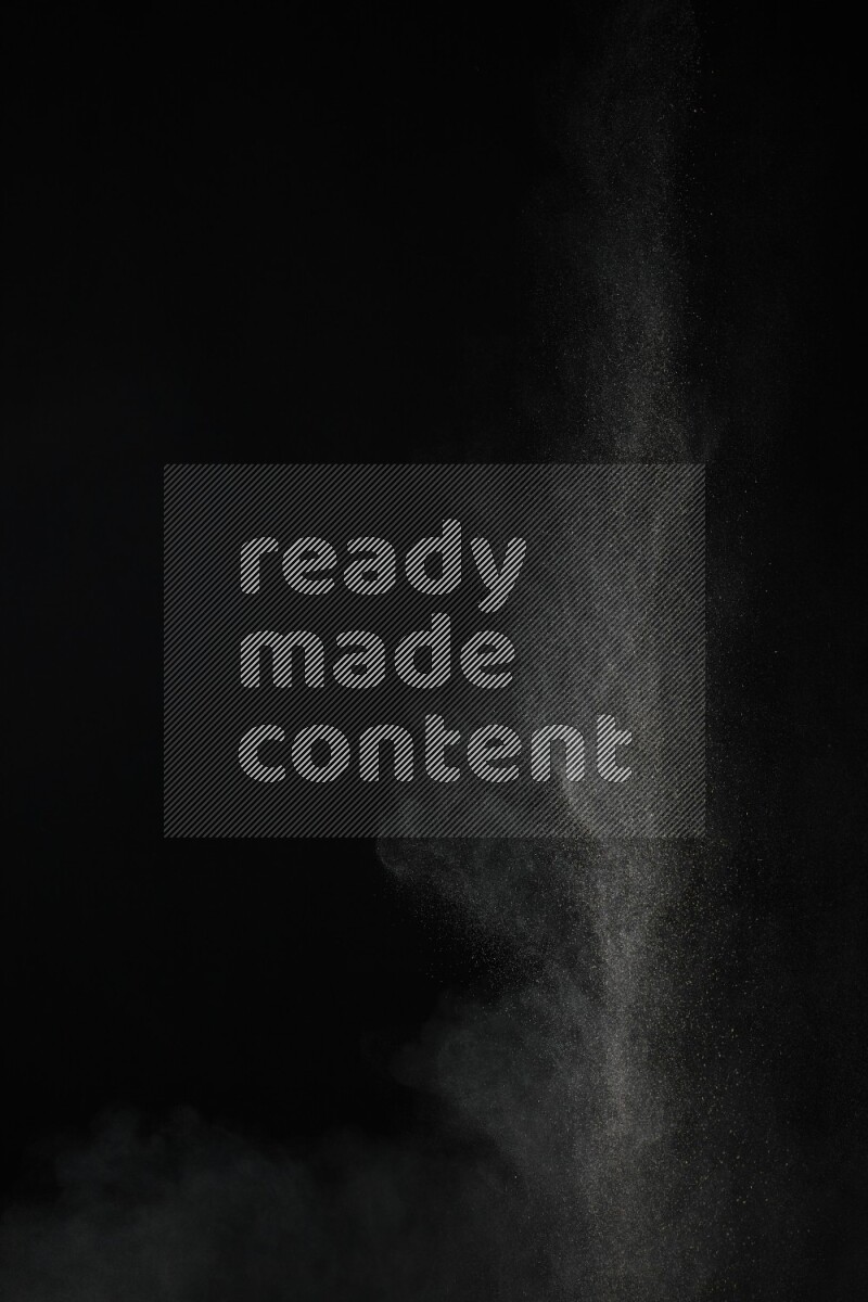 A side view of brown powder explosion on black background