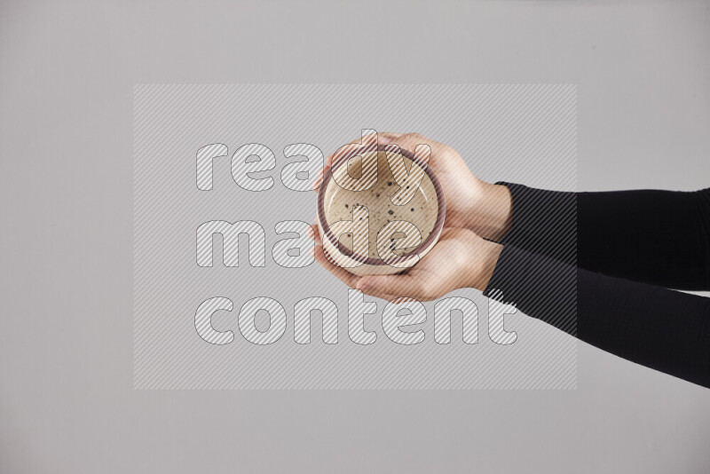 A woman in black abaya holding different pottery essentials in different positions