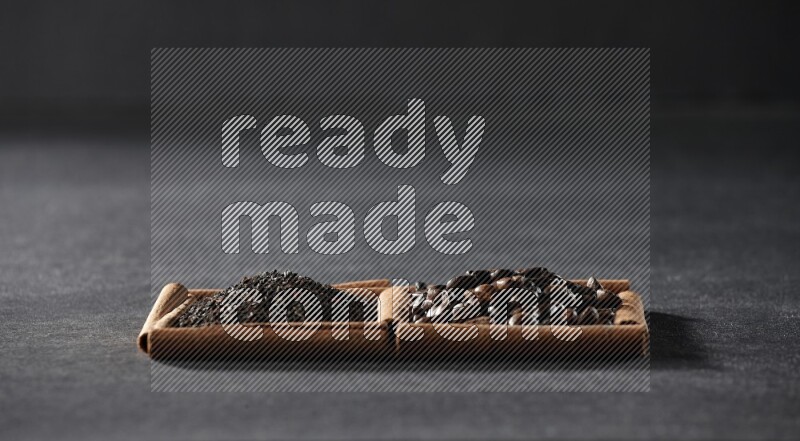 2 squares of cinnamon sticks full of coffee beans and tea on black flooring