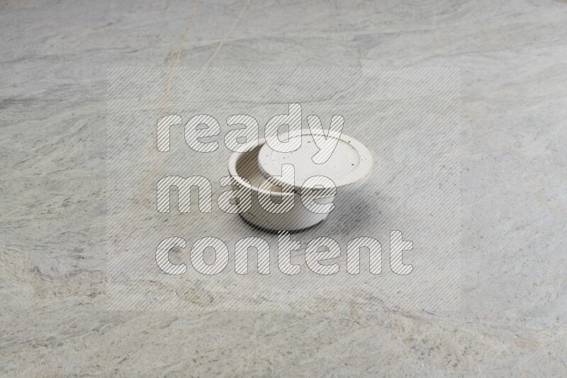A white pottery bowl on grey marble background