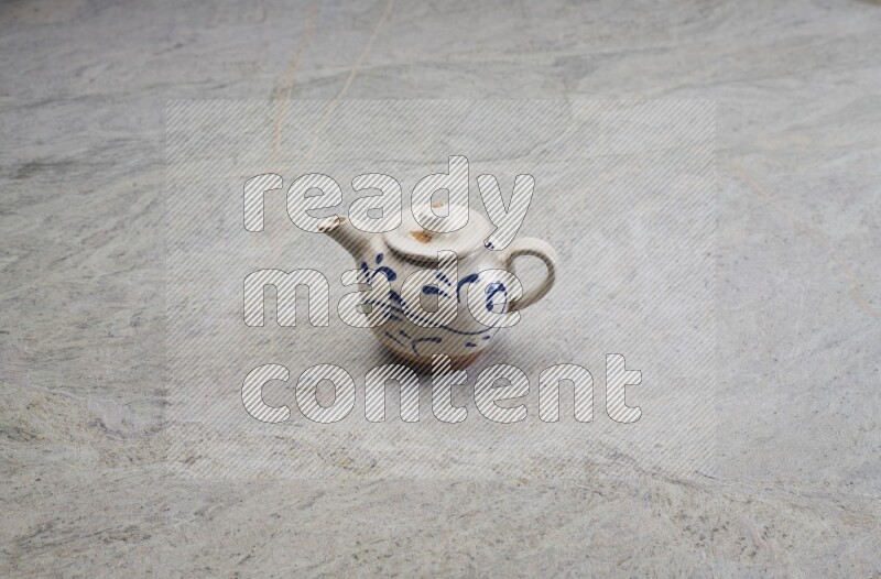 A pottery teapot on grey marble background
