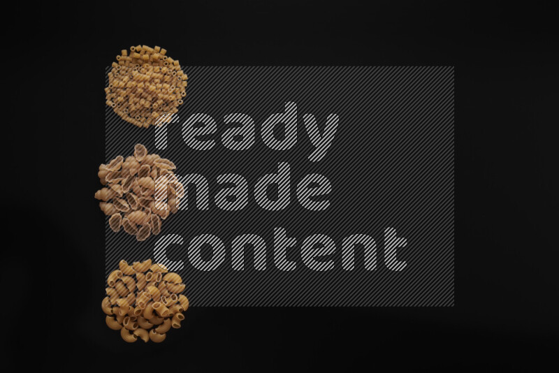 Different pasta types in 3 bunches on black background