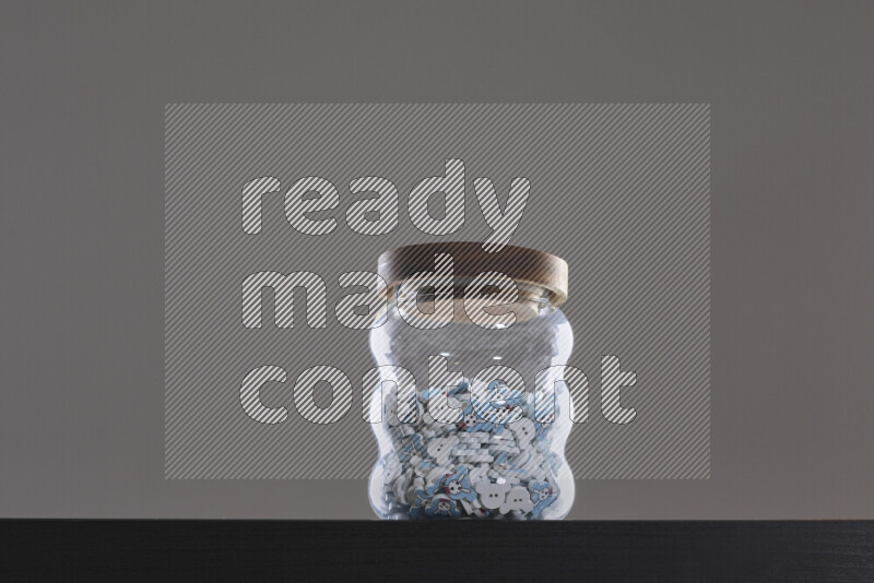 Buttons in a glass jar on black background