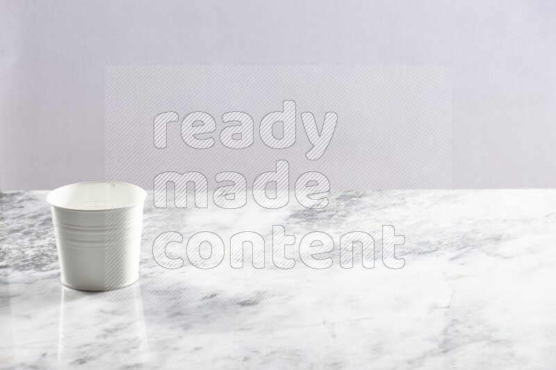 An empty white plant pot on grey marble background