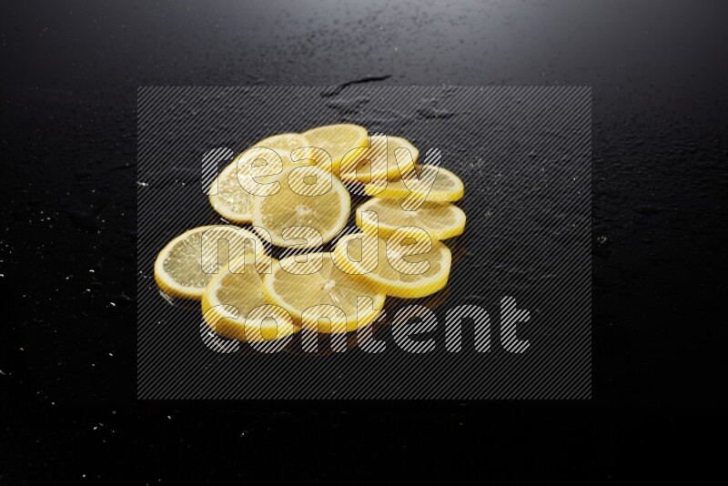 Lemon slices with water drops, and droplets on black background