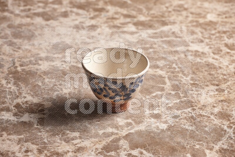 A decorative pottery bowl on beige marble background