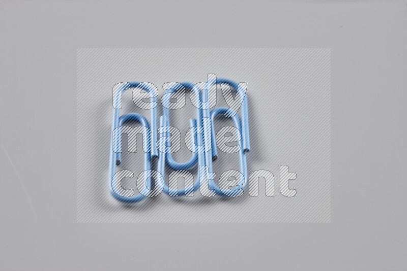 Blue paper clips isolated on a grey background
