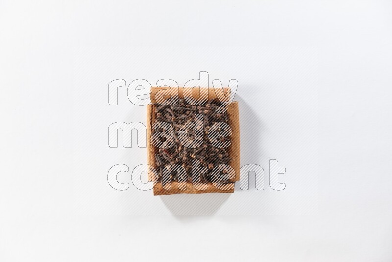 A single square of cinnamon sticks full of cloves on white flooring