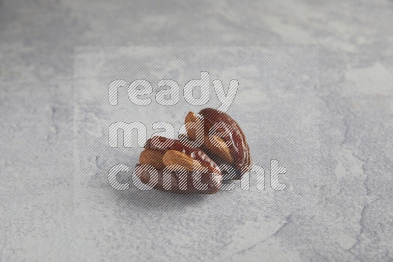 Two Almond stuffed date on a light grey background