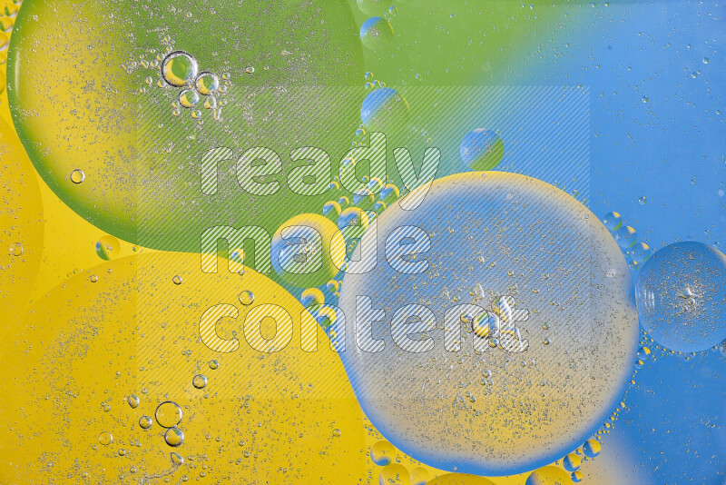 Close-ups of abstract oil bubbles on water surface in shades of yellow, green and blue