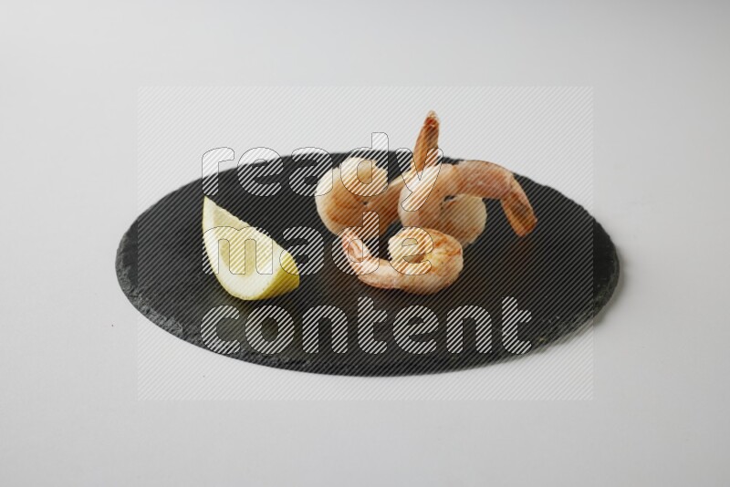 three grilled shrimp  on a black slate direct  on a white back ground