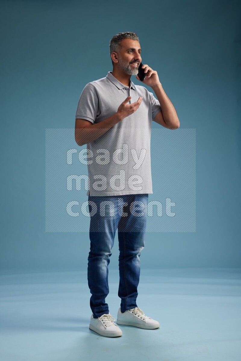 Man Standing talking on phone on blue background