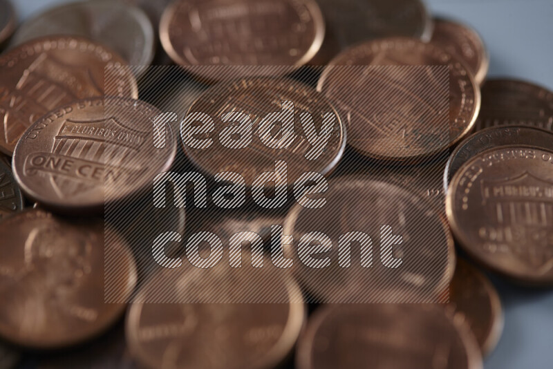 A close-up of scattered United States one cent coins on grey background